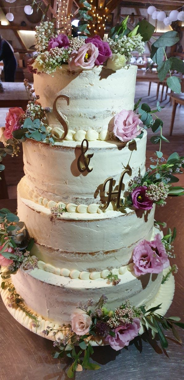 Dreistöckige Hochzeitstorte mit Blüten und Monogramm